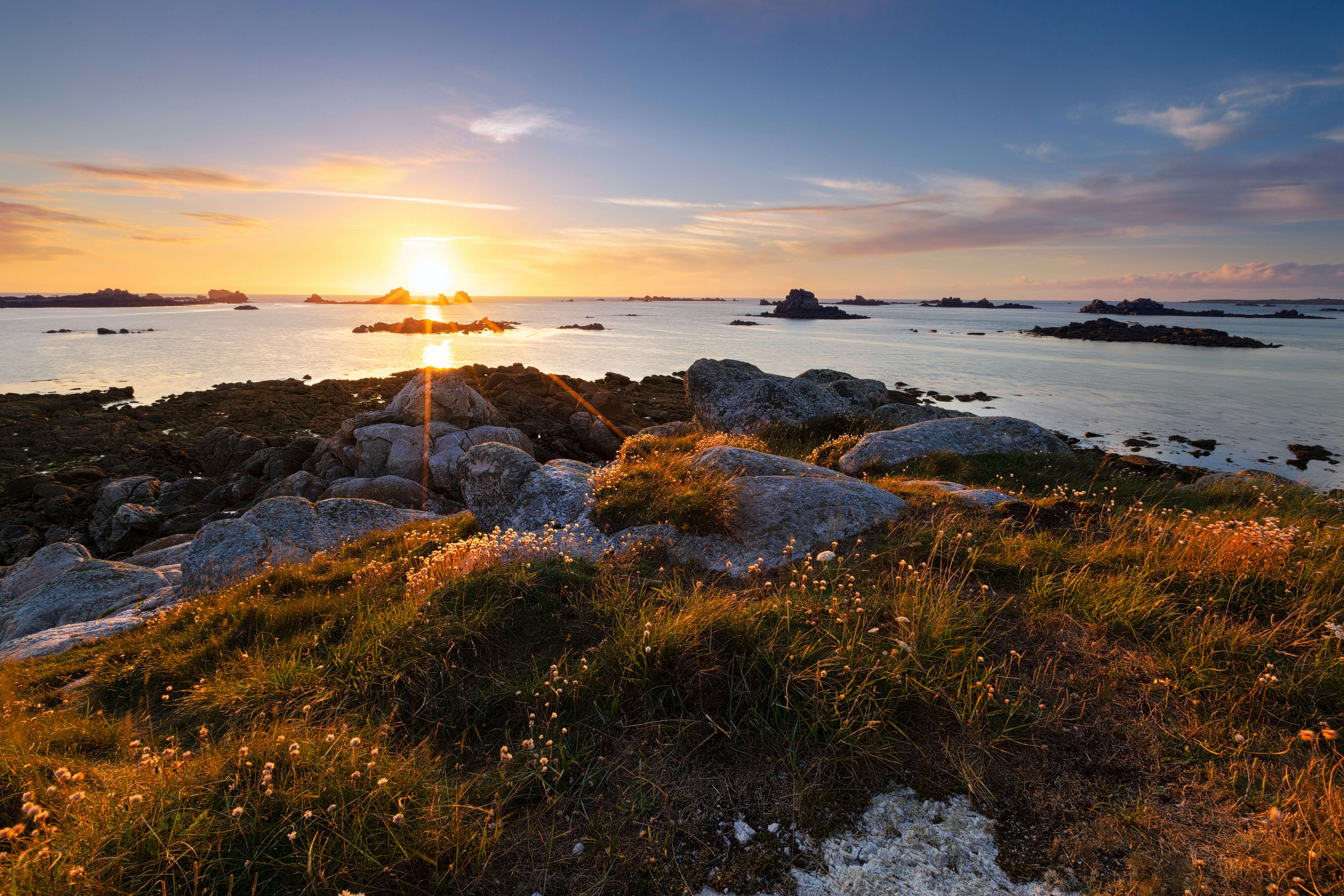 brown and gray rock formation near body of water during sunset